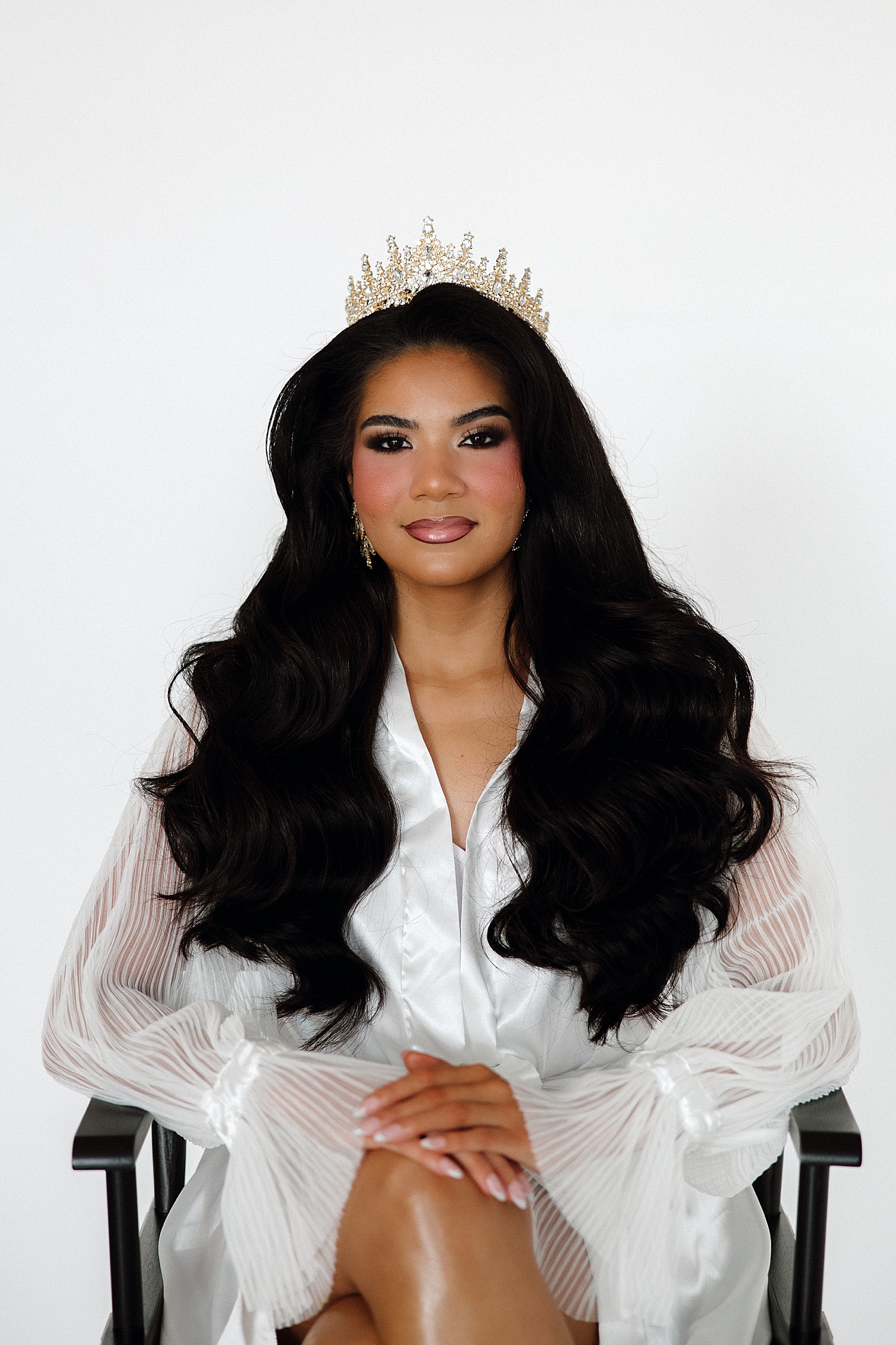 model shows off crown in chair by Tampa boudoir photographer