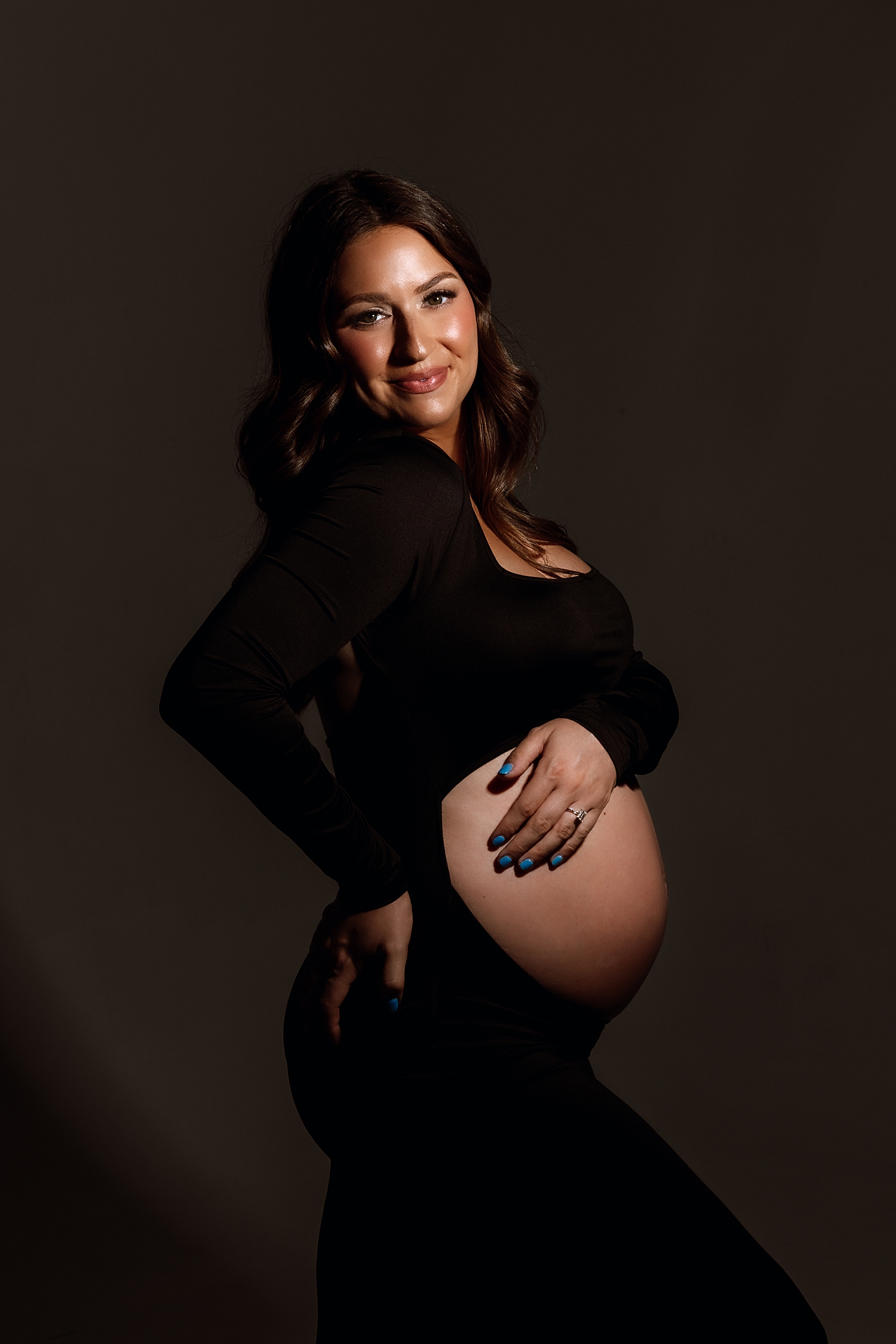brunette cradles pregnancy belly by Love Kay Collective