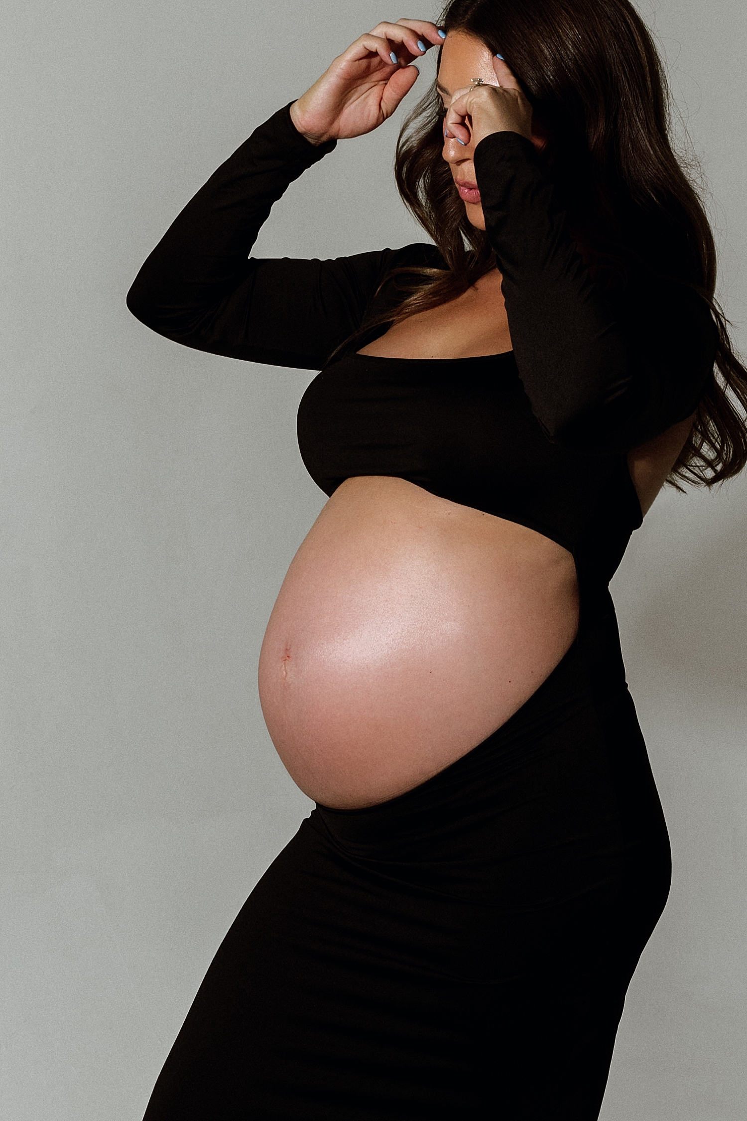 pregnant mom adjust her hair by Love Kay Collective