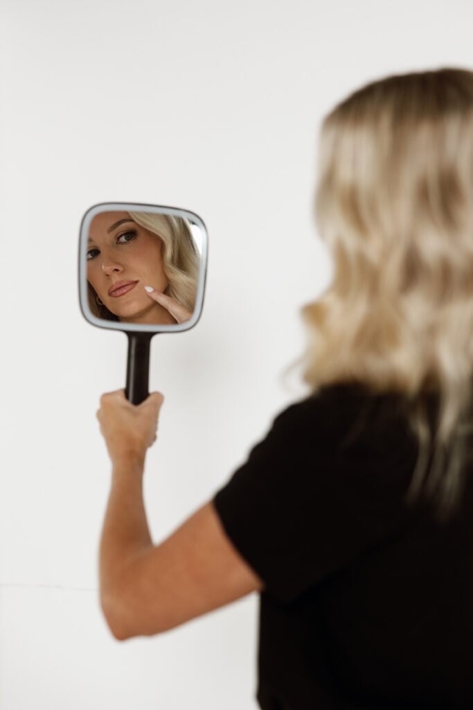 Confident female injector captured in scrubs as part of a modern, clean branding photo session in Florida.

