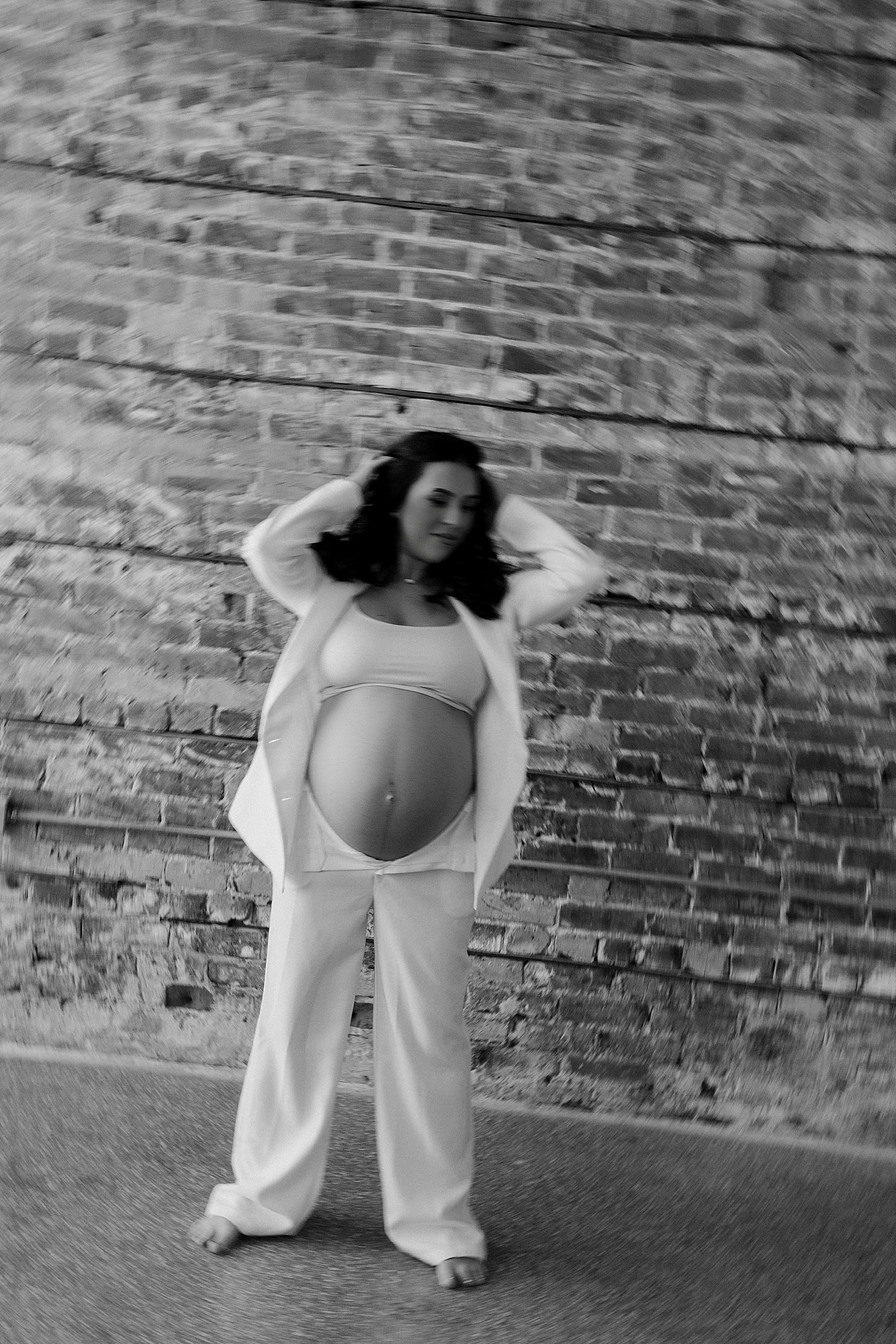 pregnant mom stands in front of brick wall by Tampa boudoir photographer